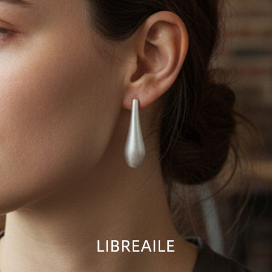 Matte silver raindrop earrings worn on model, minimalist style