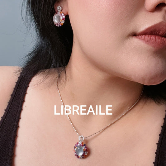 Layered silver necklace and stud earrings set on model